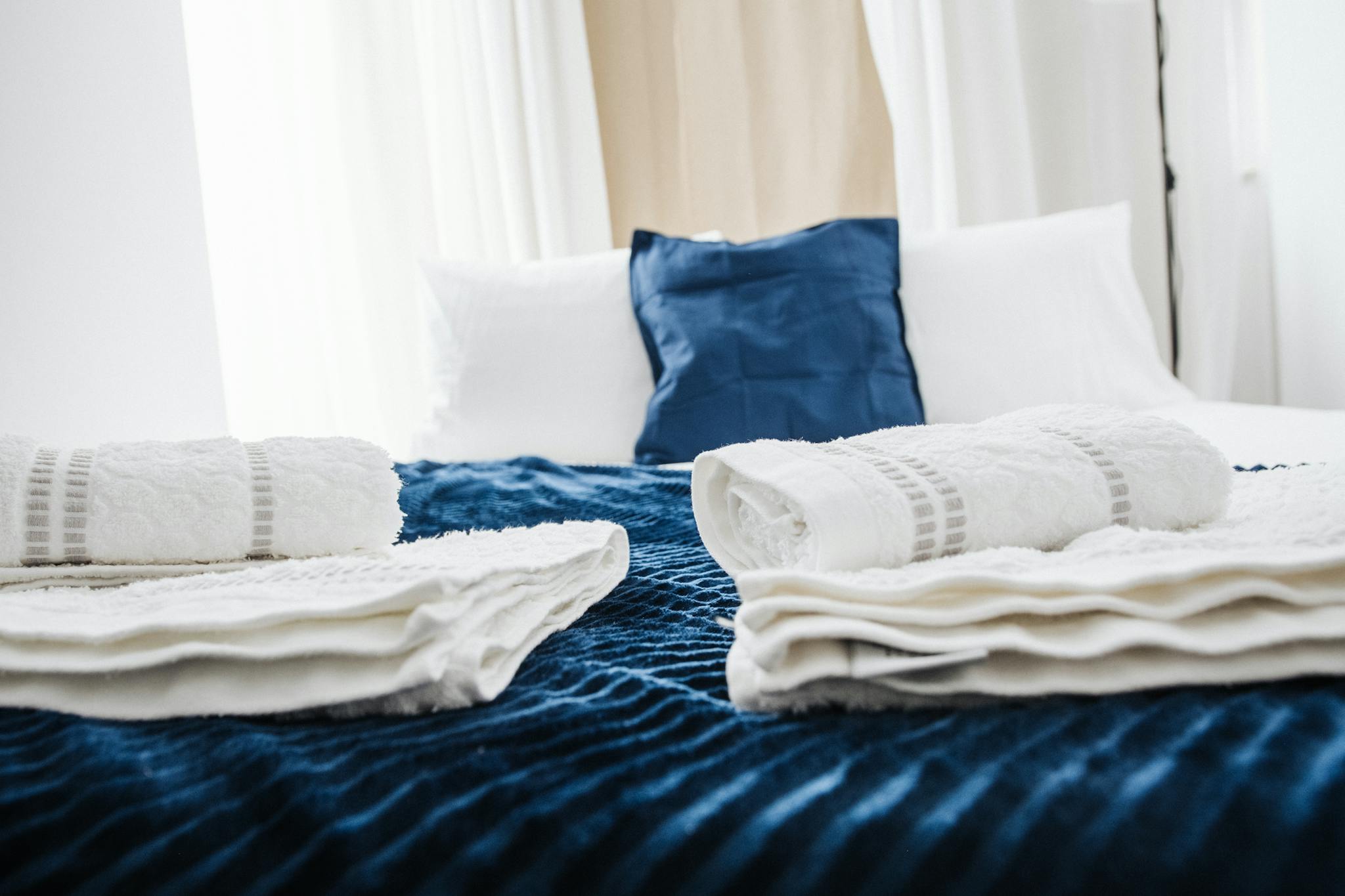 Elegant hotel room showcasing neatly arranged fresh towels and plush bedding in a contemporary setting.