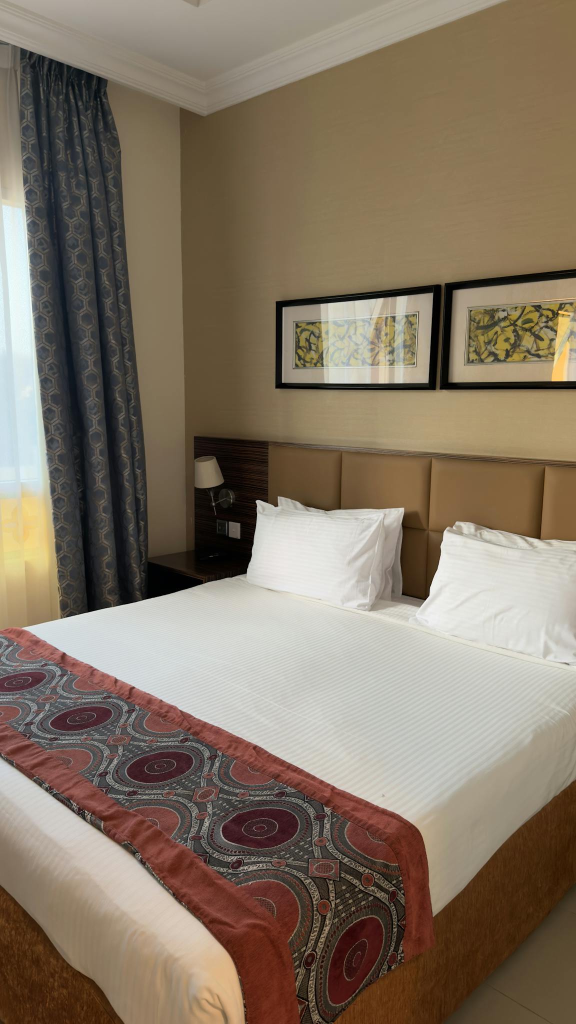 Inviting hotel room featuring modern decor and abundant natural light, perfect for a relaxing stay.
