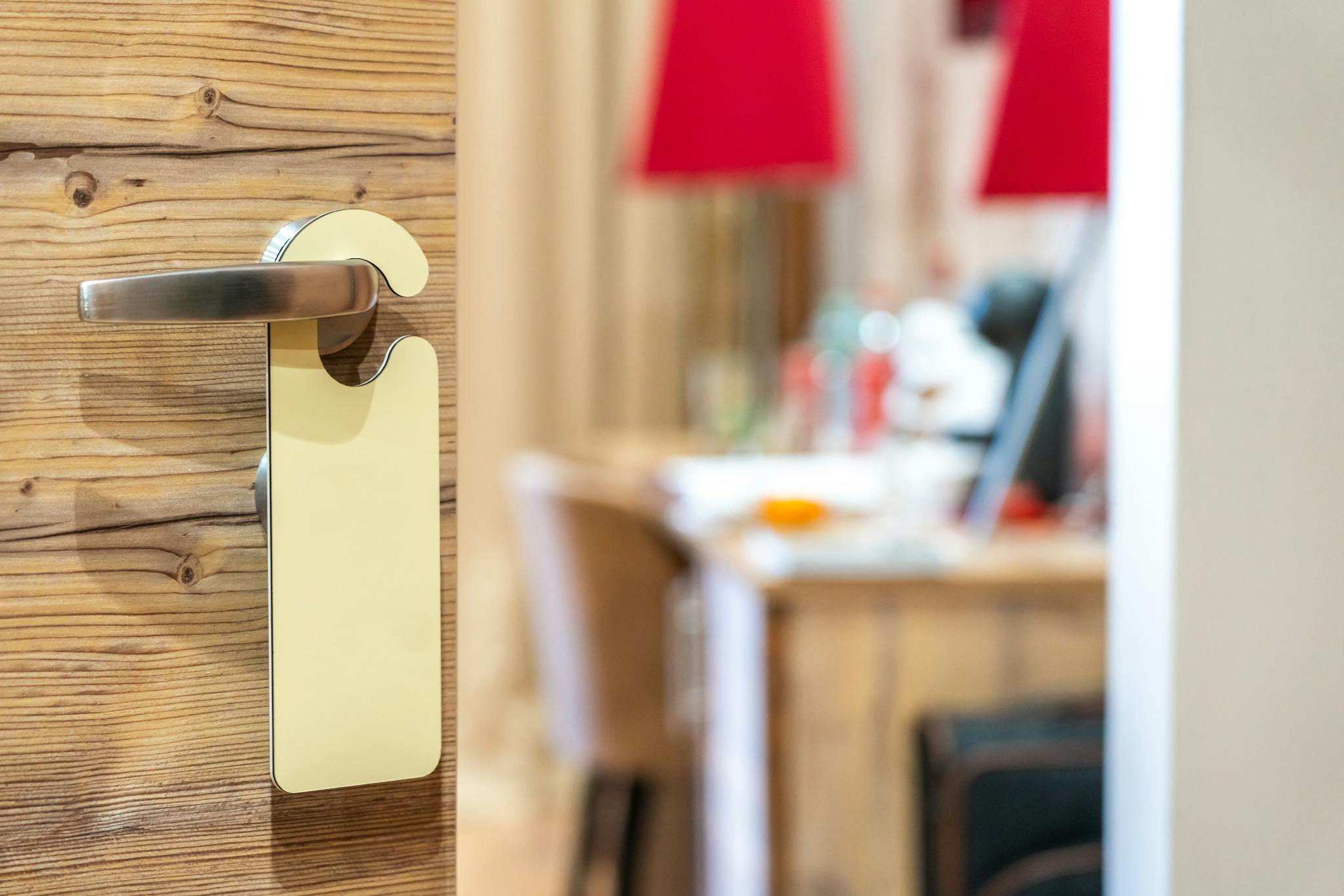 Stylish hotel room door handle with a blank sign in a well-decorated interior.